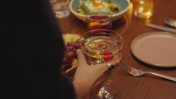 Elegant cocktail with fruit garnish served at a private dining table