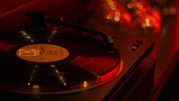 Close-up of a spinning vinyl record on a turntable with warm lighting