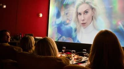 Guests enjoying a private screening in a Metro Private Cinema suite with plush seating and a large projection screen