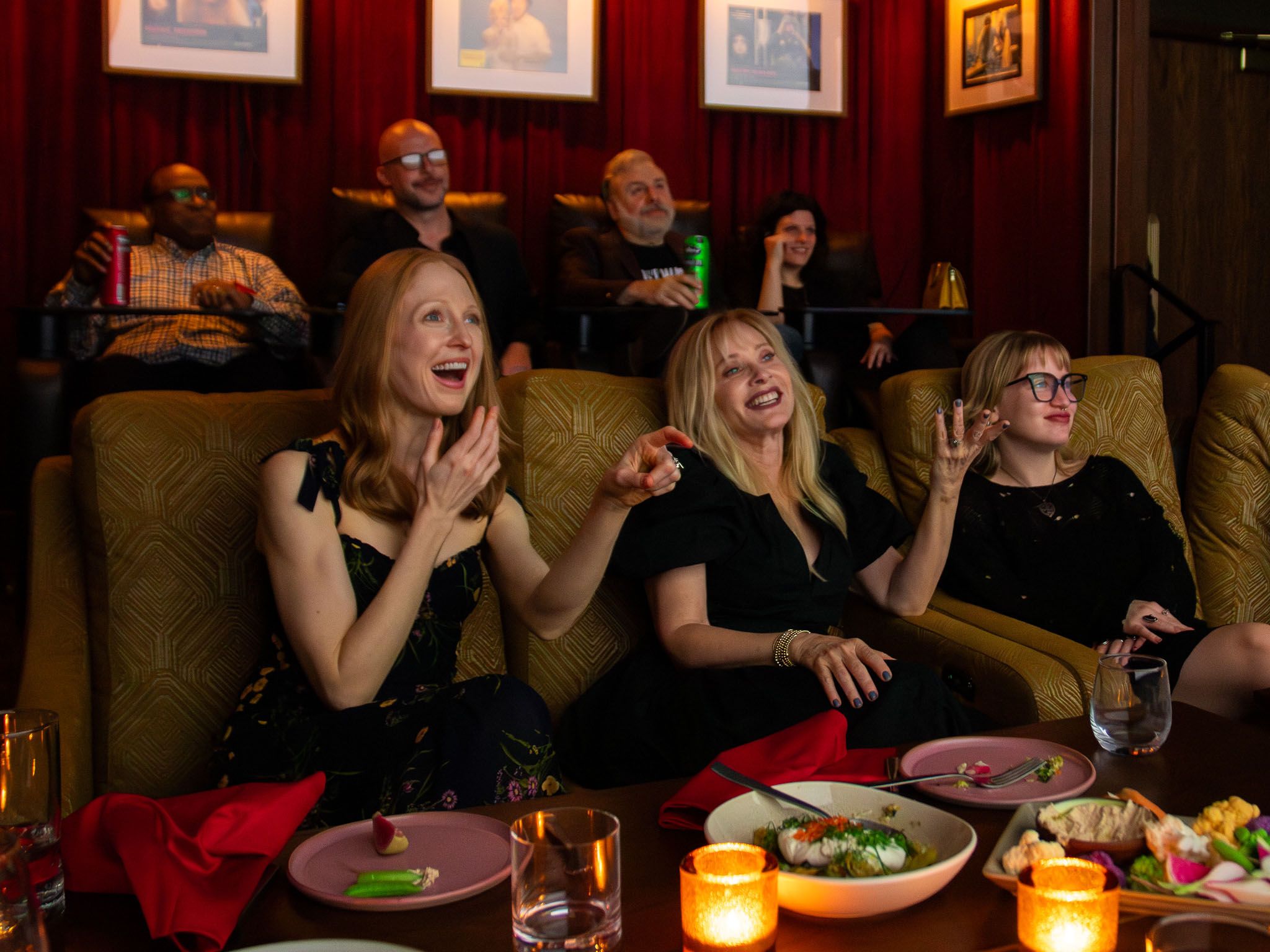 Guests laughing in a private cinema dining suite.